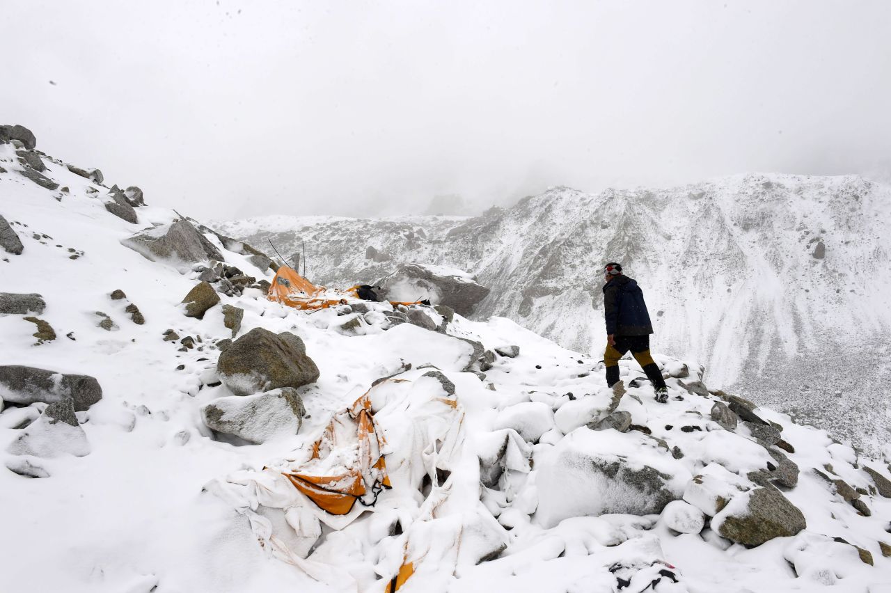 Expedition guide Pasang Sherpa runs toward flattened tents on April 25 in search of survivors, shortly after an avalanche that flattened parts of Everest base camp. 