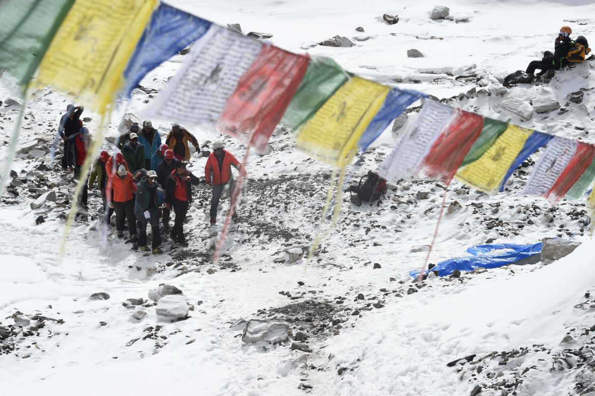 Rescue team personnel carry an injured person toward a waiting rescue helicopter on April 26 at Everest base camp.