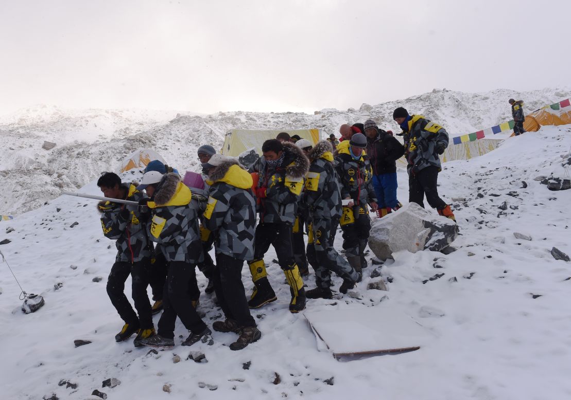 An injured person is carried by rescuers on April 26 to be airlifted by helicopter at Everest base camp.