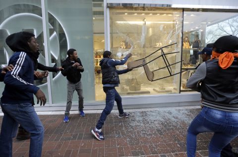 A protester breaks a store window after the rally in Baltimore on April 25.