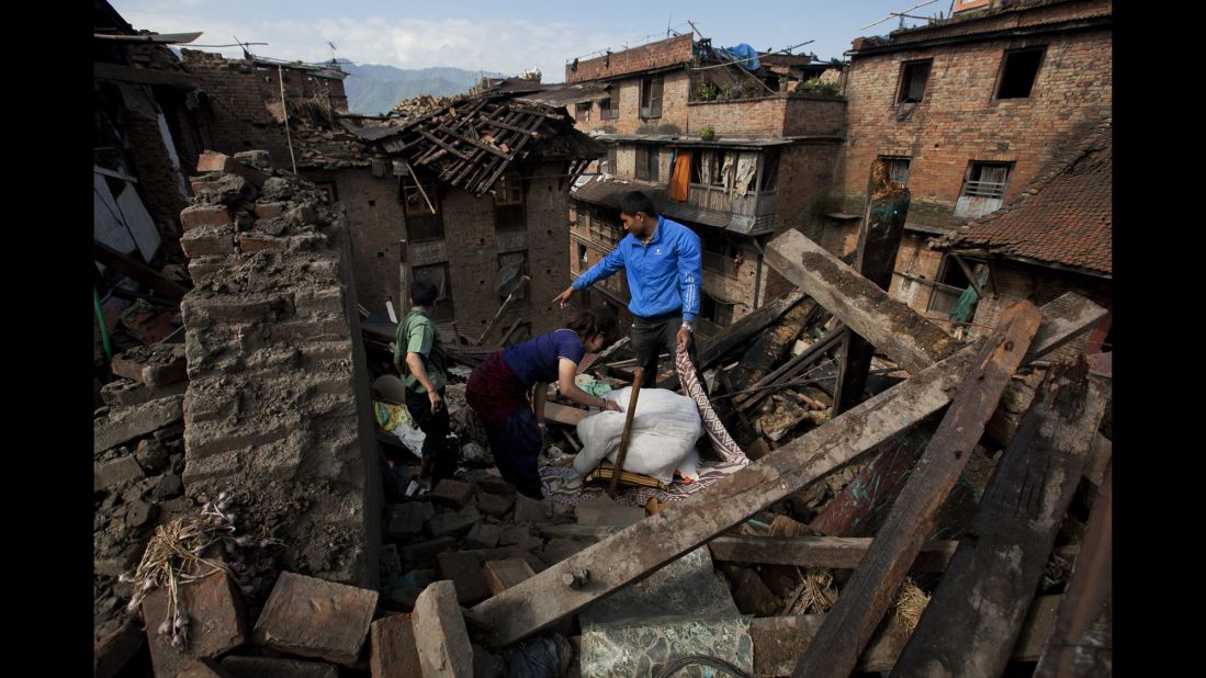 A family collects belongings from their home in Bhaktapur, Nepal, on Monday, April 27.