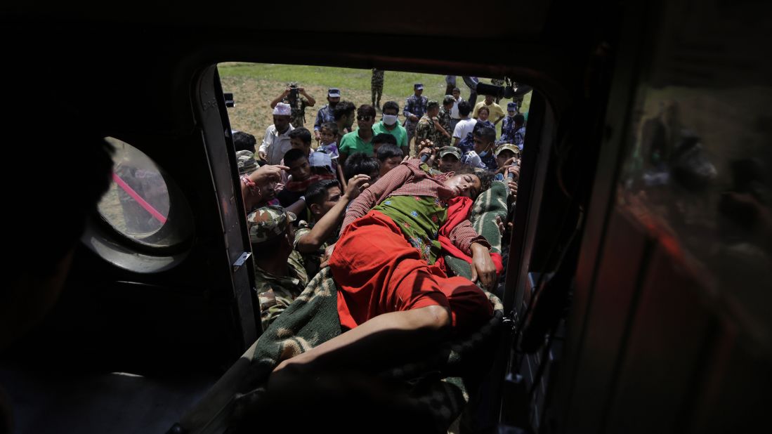 Nepalese soldiers carry a wounded woman to a helicopter as they evacuate people from Trishuli Bazar, Nepal, on April 27.