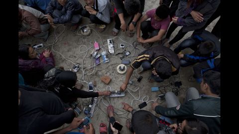 People charge their cell phones in an open area in Kathmandu on April 27.