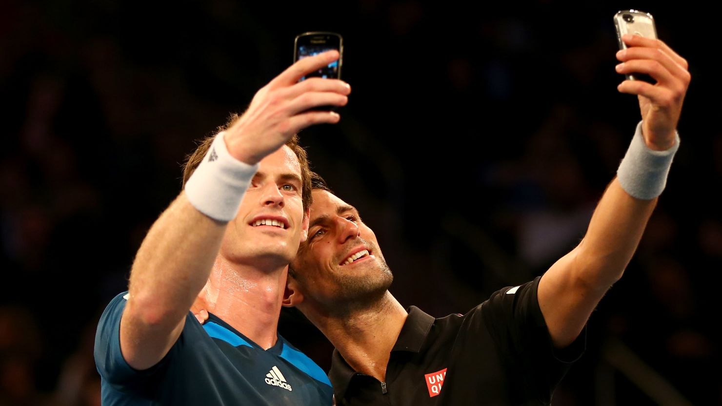 Wimbledon winners Andy Murray and Novak Djokovic take selfies together.
