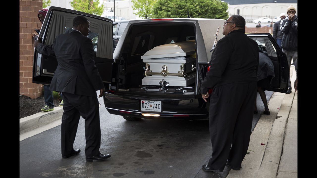 Men prepare to remove Gray's casket from the hearse in front of the church.