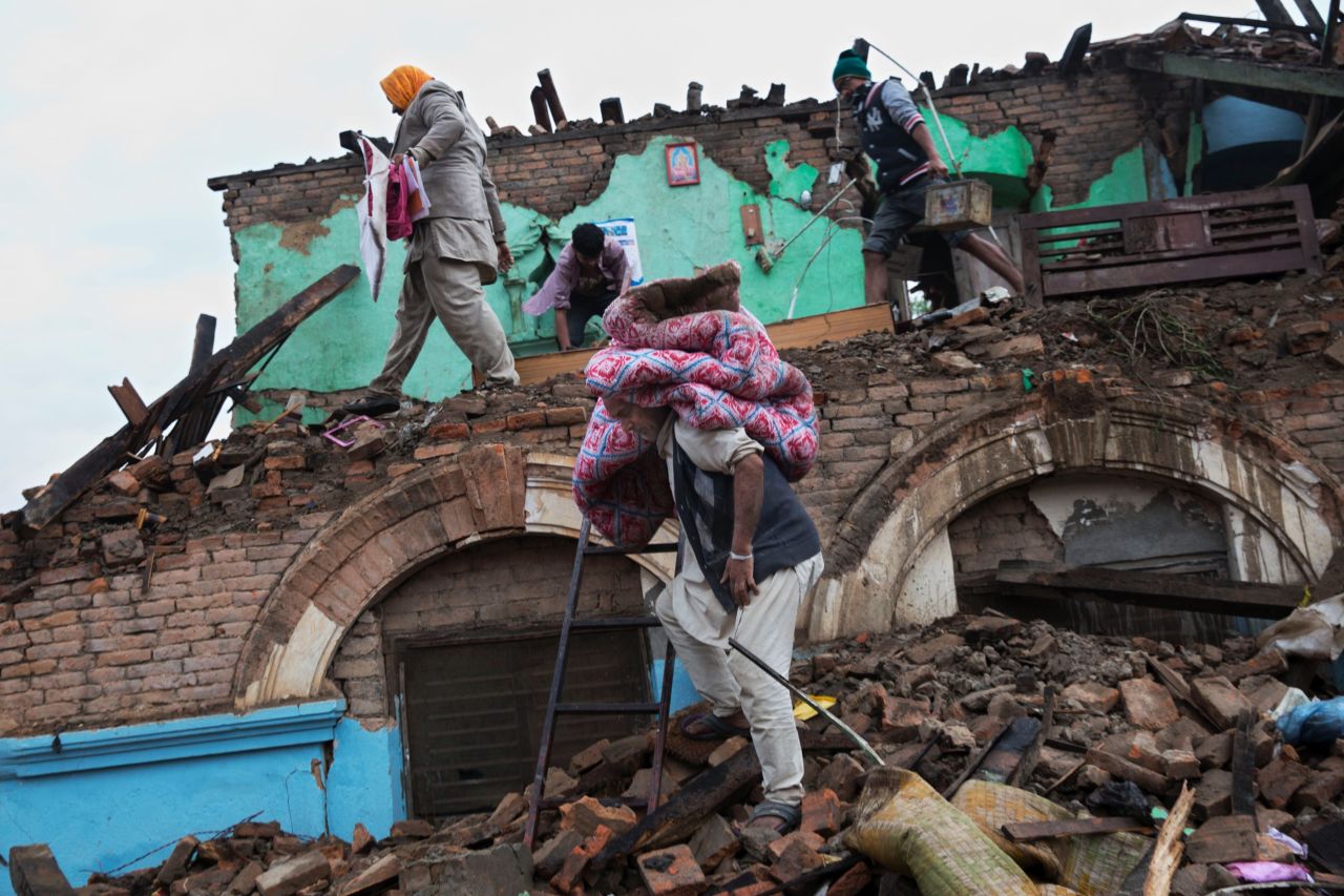 Residents rescue items from the debris of houses damaged in the quake in Kathmandu on April 27.