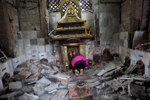 A woman prays at a ruined temple in Kathmandu on April 27.
