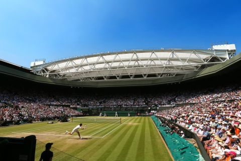 Under bright blue skies, Murray plays a forehand on his way to victory over Novak Djokovic in the 2013 Wimbledon final in front of a capacity 15,000 crowd on Centre Court.