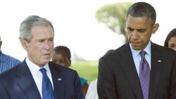 US President Barack Obama (R) and former US President George W. Bush (2nd R) bow their heads on July 2, 2013 alongside victims during a wreath-laying ceremony for the victims of the 1998 US Embassy bombing at the Bombing Memorial at the US Embassy in Dar Es Salaam. Bush is in Tanzania for a forum of regional First Ladies, hosted by his wife Laura, which will also be attended by First Lady Michelle Obama.