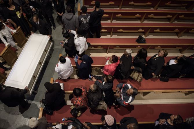 People watch as Gray's casket is carried out of the church.