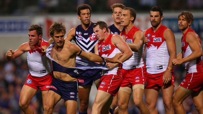 Ben McGlynn, left, and Harry Cunningham, center right, of the Swans wrestle with Matt de Boer, middle, of the Dockers during the round four Australian Football League match between the Fremantle Dockers and the Sydney Swans on Saturday, April 25, in Perth.