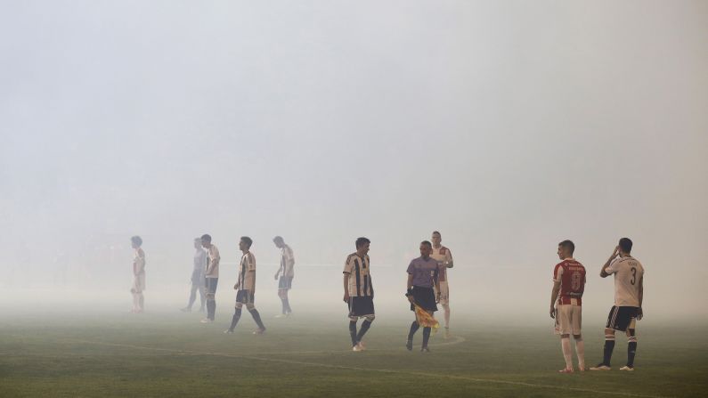 Red Star Belgrade and Partizan Belgrade players stand on the field in Belgrade, Serbia, on Saturday, April 25. The game, which ended with a 0-0 score, was delayed for 45 minutes because of crowd behavior. 