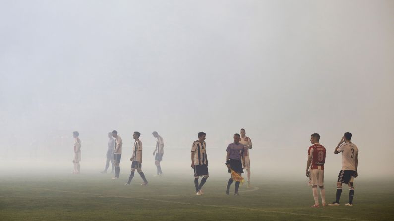 Red Star Belgrade and Partizan Belgrade players stand on the field in Belgrade, Serbia, on Saturday, April 25. The game, which ended with a 0-0 score, was delayed for 45 minutes because of crowd behavior.