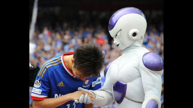 Yokohama F. Marinos soccer player Manabu Saito shakes hands with a "Dragon Ball Z" character after the J. League match against Shonan Bellmare on Saturday, April 25, in Yokohama, Japan.