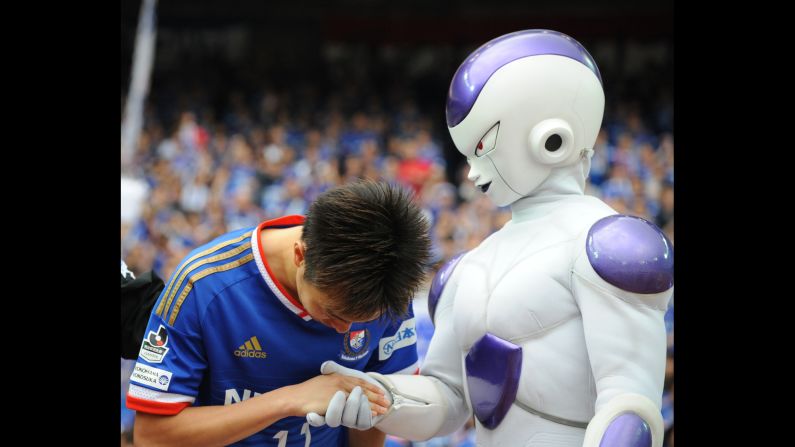 Yokohama F. Marinos soccer player Manabu Saito shakes hands with a "Dragon Ball Z" character after the J. League match against Shonan Bellmare on Saturday, April 25, in Yokohama, Japan. 