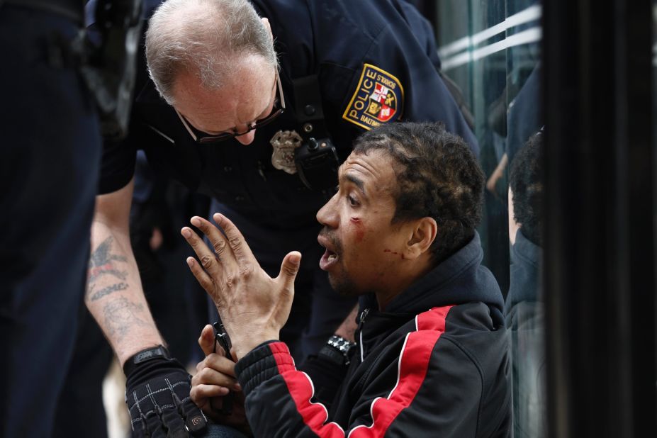 A police officer checks on a man who was injured on April 27.