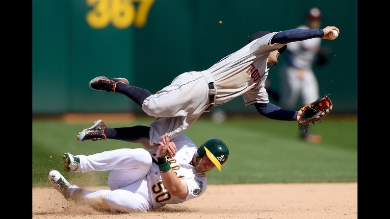 Max Muncy of the Oakland Athletics breaks up a double-play as he slides into Jose Altuve of the Houston Astros on Saturday, April 25, in Oakland, California. The Astros won the game 9-3.<br />