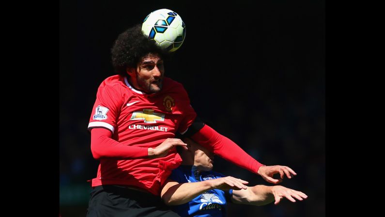 Marouane Fellaini of Manchester United heads the ball over Gareth Barry of Everton on Sunday, April 26, in Liverpool. Everton won the match 3-0.<br />