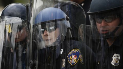 Baltimore police officers in riot gear look toward protesters near Mondawmin Mall on April 27.