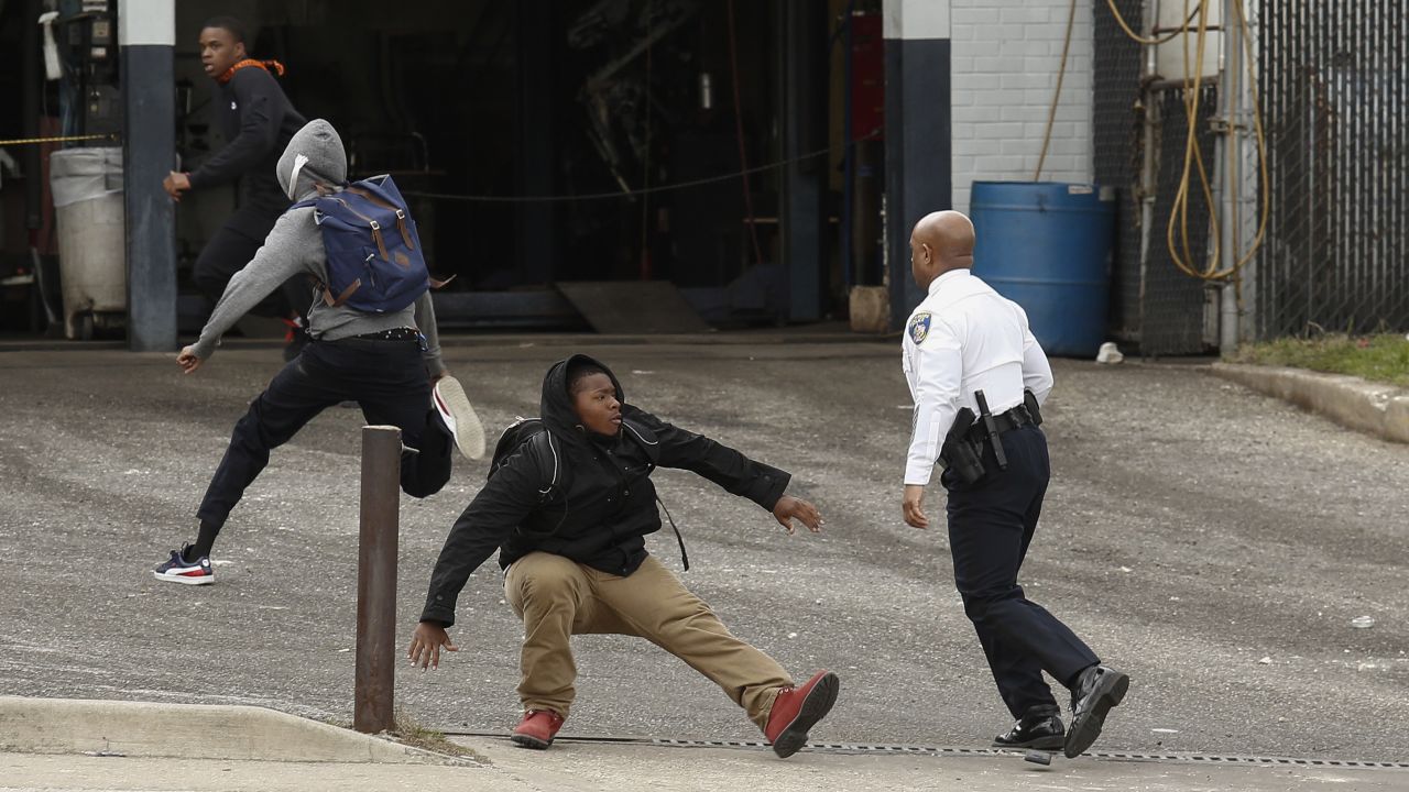 Baltimore Police Commissioner Anthony Batts chases away protesters in a parking lot on April 27.