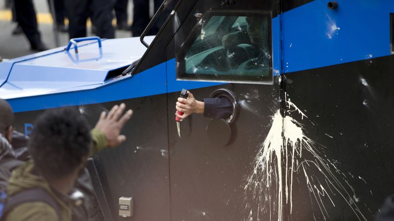 A police officer uses pepper spray on rioters on April 27.