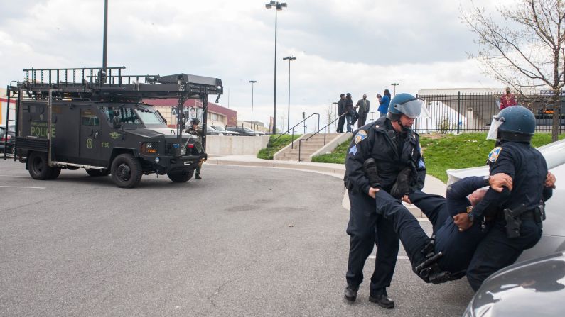A police officer is carried to safety after being hit in the head with a rock during the riot on April 27.