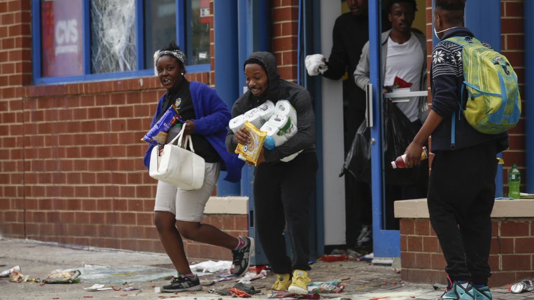 People carry goods out of a CVS pharmacy on April 27.