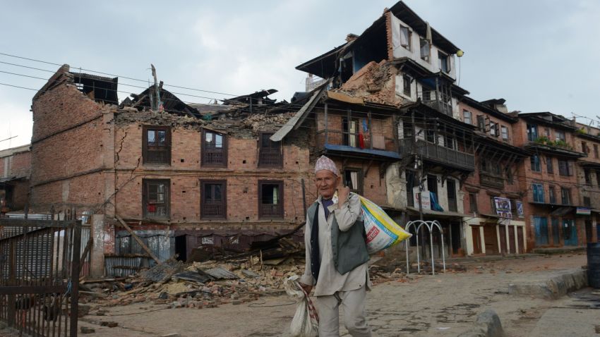 A man walks next to collapsed houses in Bhaktapur, on the outskirts of Kathmandu, on April 27, 2015, two days after a 7.8 magnitude earthquake hit Nepal.