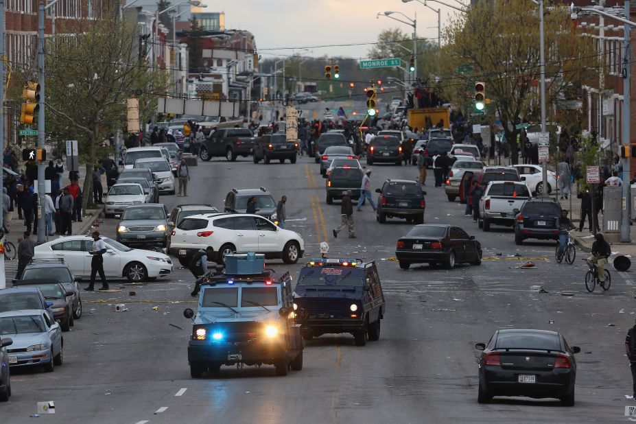 Armored cars drive down Pennsylvania Avenue as looters break into shops on April 27.