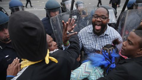 A man shouts for calm as protesters clash with police April 27.