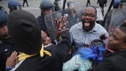 A man shouts for calm as protesters clash with police April 27.