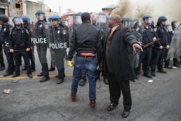 A man attempts to calm a fellow demonstrator as they face off with Baltimore police on Monday.