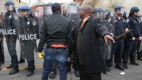 A man attempts to calm a fellow demonstrator as they face off with Baltimore police on Monday.