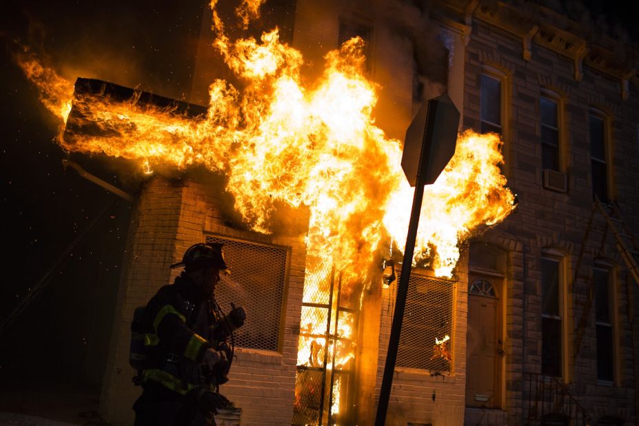 Firefighters respond to a burning building during the riots late April 27.