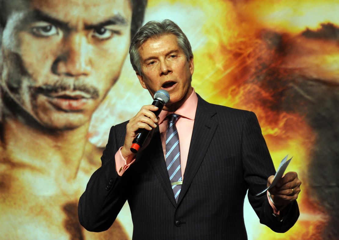 Michael Buffer speaks in front of a poster of Manny Pacquiao.