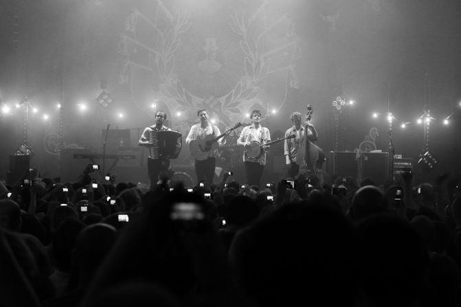 A shot from the crowd shows retro-styled folk rockers Mumford & Sons in an intimate setting. 