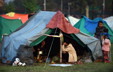 People rest April 28 in a temporary housing camp in Kathmandu. Large encampments of tents have sprung up in open areas, including a wide space belonging to the military in the center of the capital. 