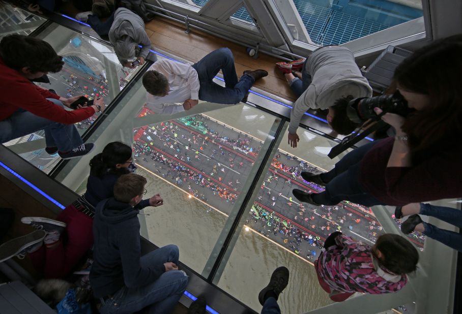 APRIL 26 - LONDON: Spectators watch through the glass floor of Tower Bridge as runners in the London Marathon pass by beneath their feet. Some 38,000 people raced along the 26.2 mile course which ends on The Mall in front of Buckingham Palace.