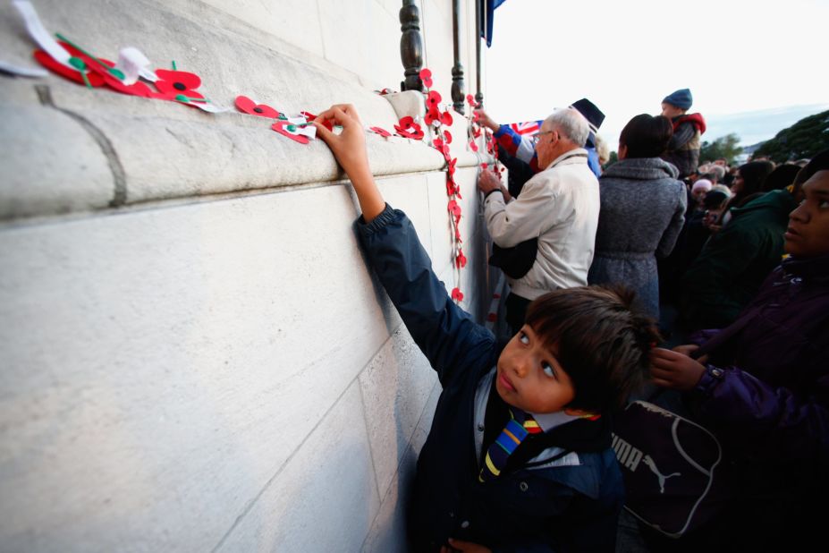 APRIL 25 - AUCKLAND, NEW ZEALAND: People pin poppies to the Cenotaph following the Dawn Service at the Auckland War Memorial Museum on ANZAC Day, the 100th anniversary of the 1915 Gallipoli landings.