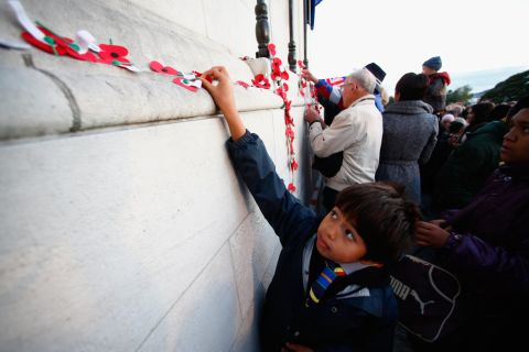 APRIL 25 - AUCKLAND, NEW ZEALAND: People pin poppies to the Cenotaph following the Dawn Service at the Auckland War Memorial Museum on ANZAC Day, the 100th anniversary of the 1915 Gallipoli landings.