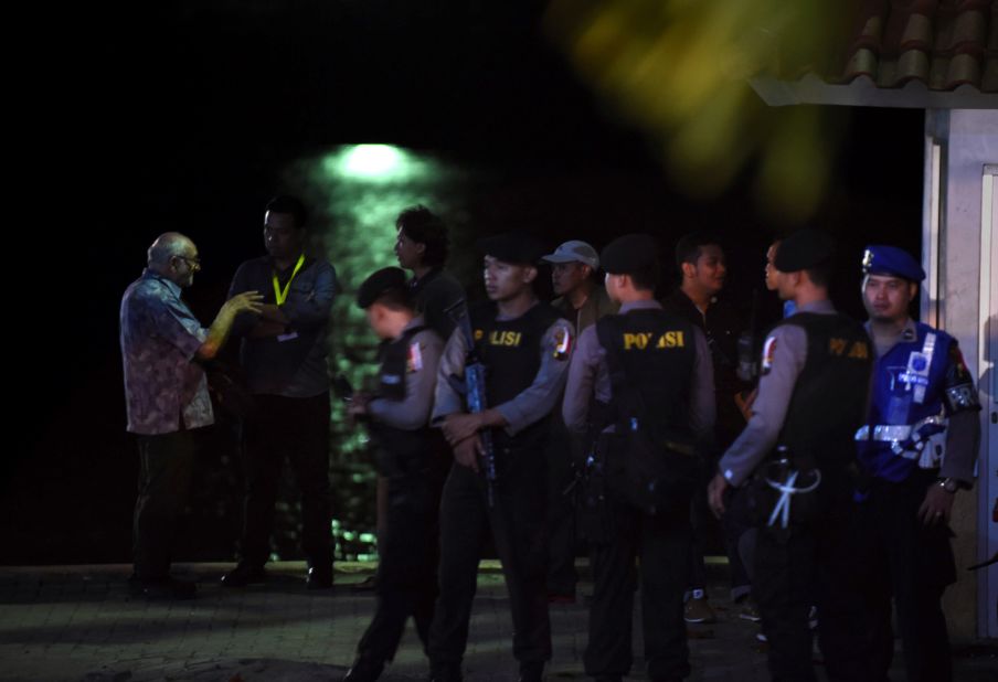 Roman Catholic priest Charlie Burrows, left, spritual adviser of Brazilian drug convict and death row prisoner Rodrigo Gularte, waits beside Indonesian police for a ferry to carry officials and representatives from families of prisoners.