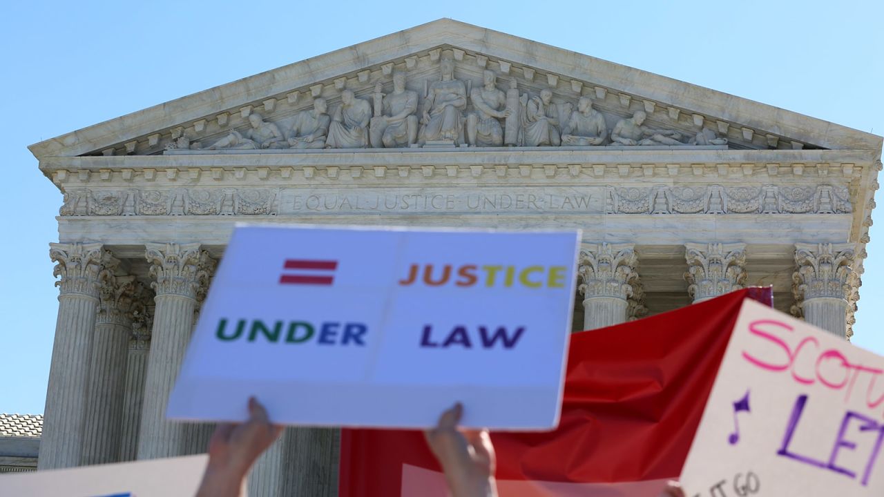Outside the Supreme Court of the United States, people hold signs calling for "equal justice under law."