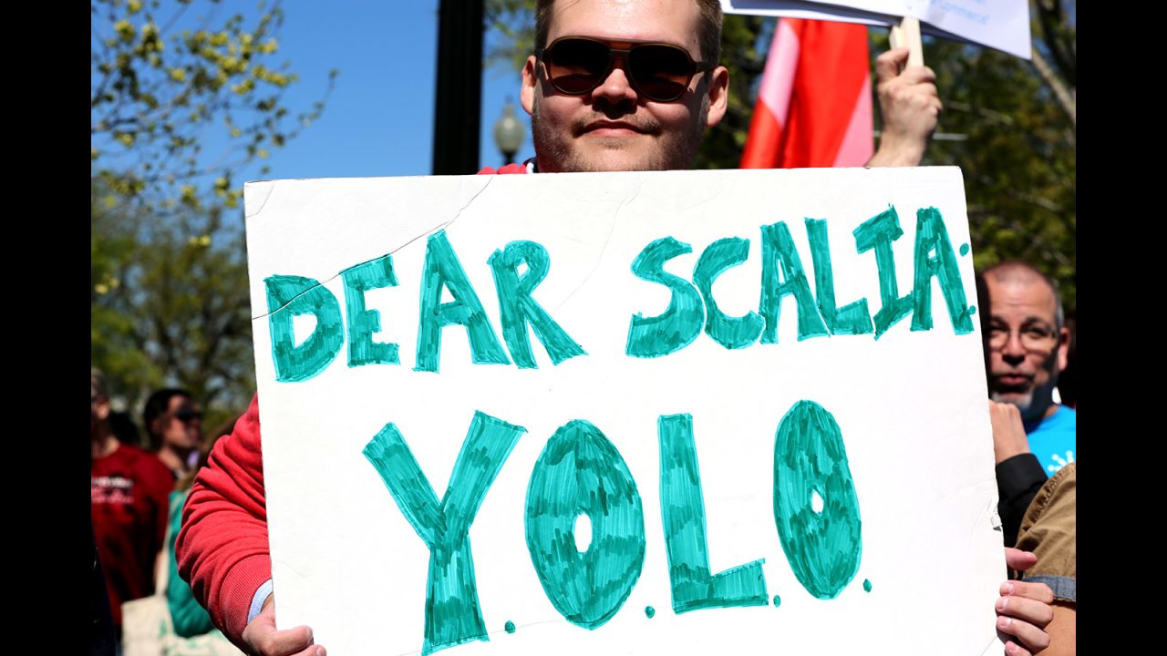 Andrew Damron of Brooklyn, New York, holds up a sign with the motto "You Only Live Once" in support of same-sex marriage.