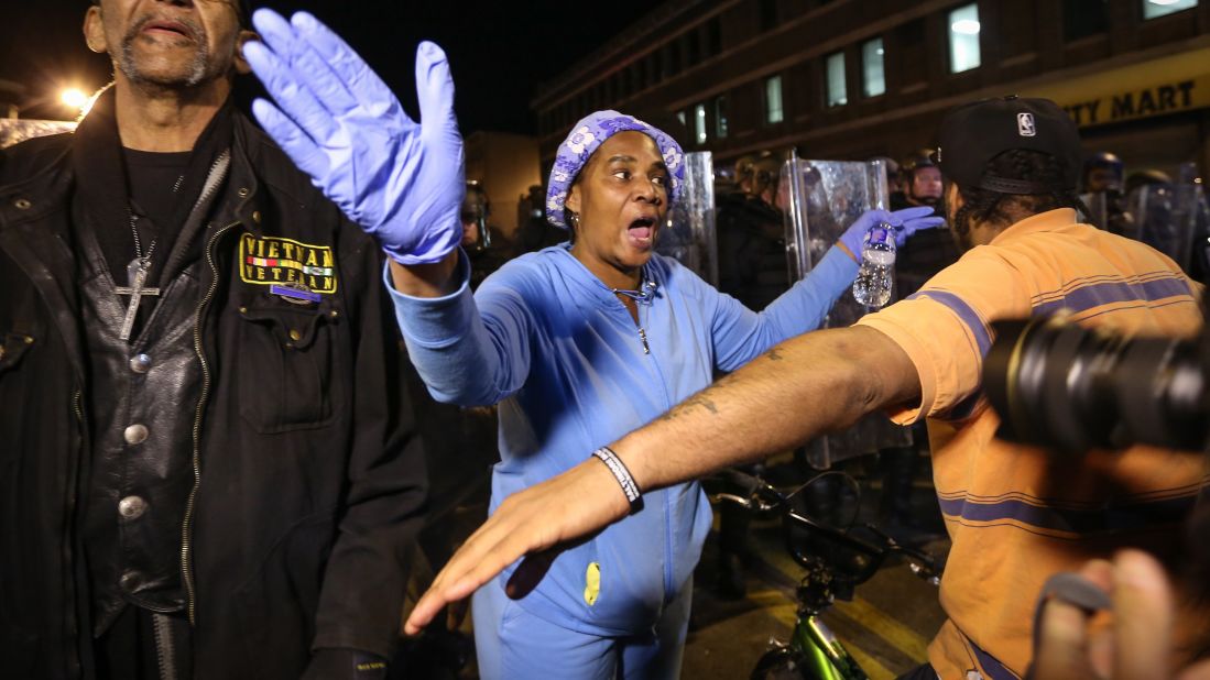 People attempt to stop protesters from approaching a police line on April 28.