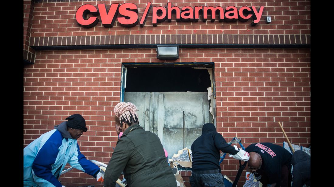Members of the community clean up debris on April 28 from the CVS that was burned and looted in the riots.
