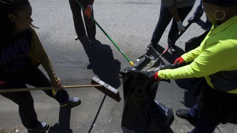 A neighborhood cleanup crew works to clear trash from the streets on April 28.