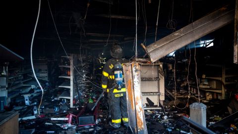 A Baltimore firefighter inspects a burned CVS store on April 28. About 200 businesses were lost in the riots.