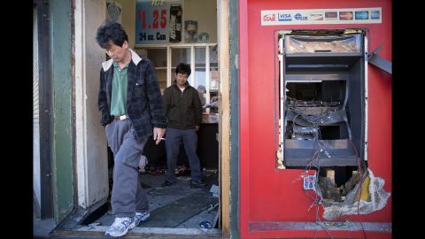 Jason Park, left, and business owner Sung Kang survey the damage to his store on April 28.