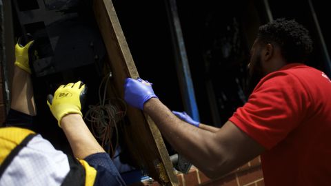 Men wearing work gloves help clear debris on April 28.