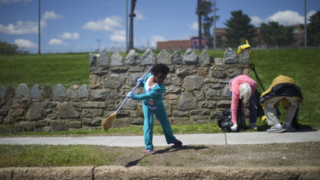 Kailah Johnson, 5, joins her mother in a neighborhood cleanup on April 28. Schools were closed across the city.